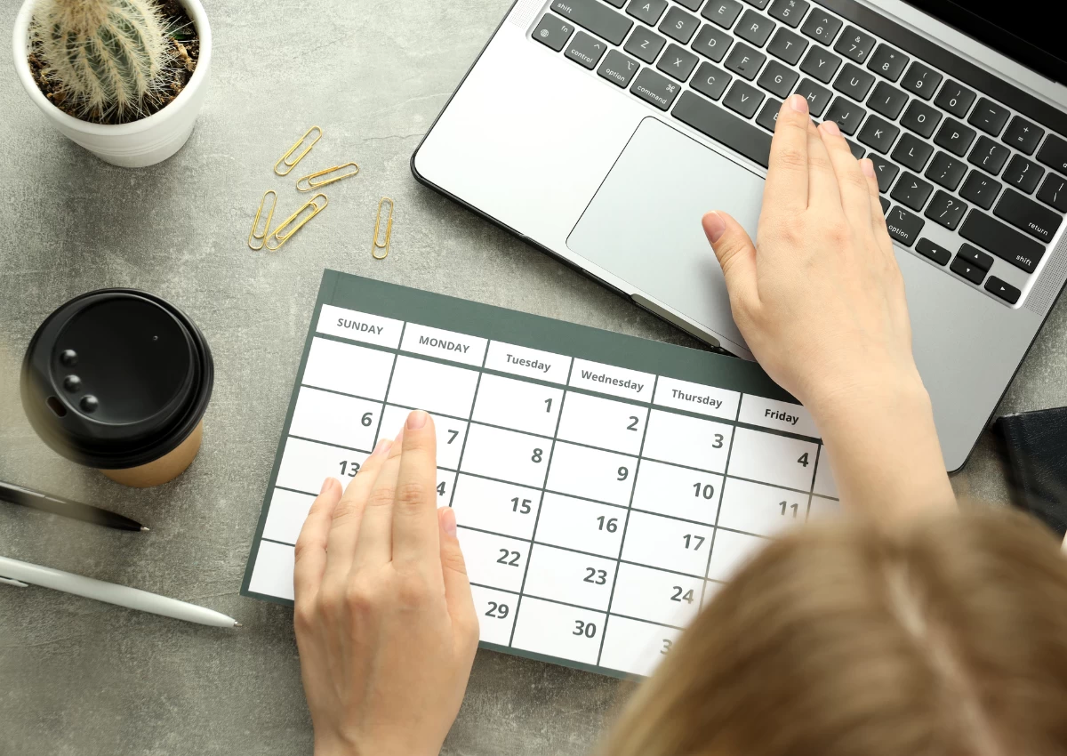 First time event organiser looking at her calendar and laptop while at planning her first event.